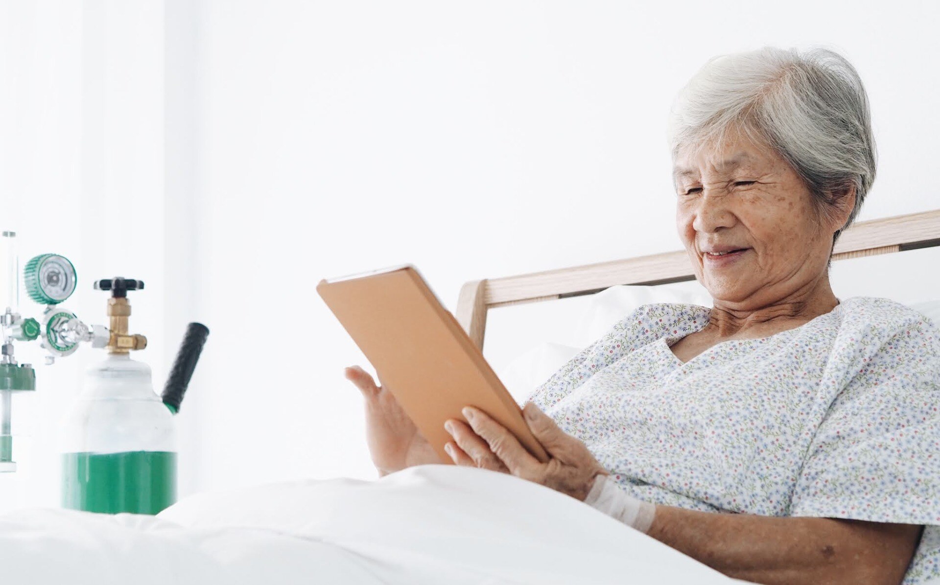 a-woman-with-an-oxygen-tank-sitting-in-bed-reading