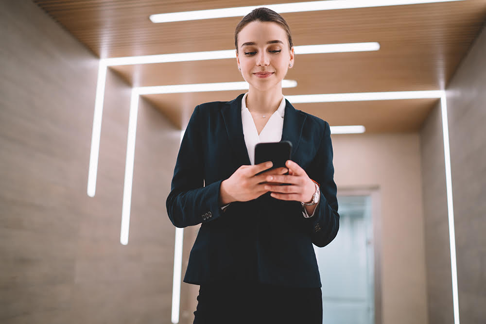 woman-staring-down-at-her-phone-wearing-suit